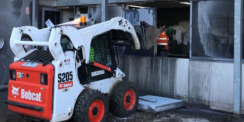 An excavator removing a wall.
