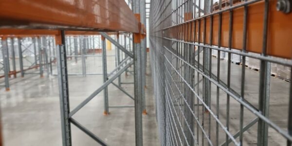 Custom fabricated steel security gate in a warehouse filled with pallet racking.