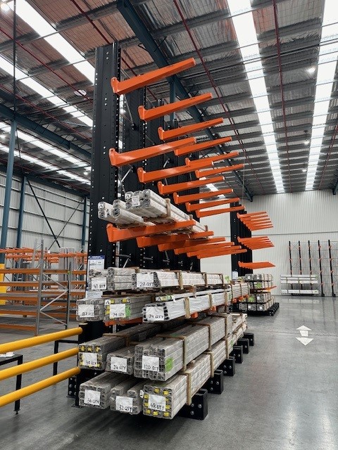 Two sets of cantilever racking in a warehouse. The cantilever racking is holding long spans of a material.