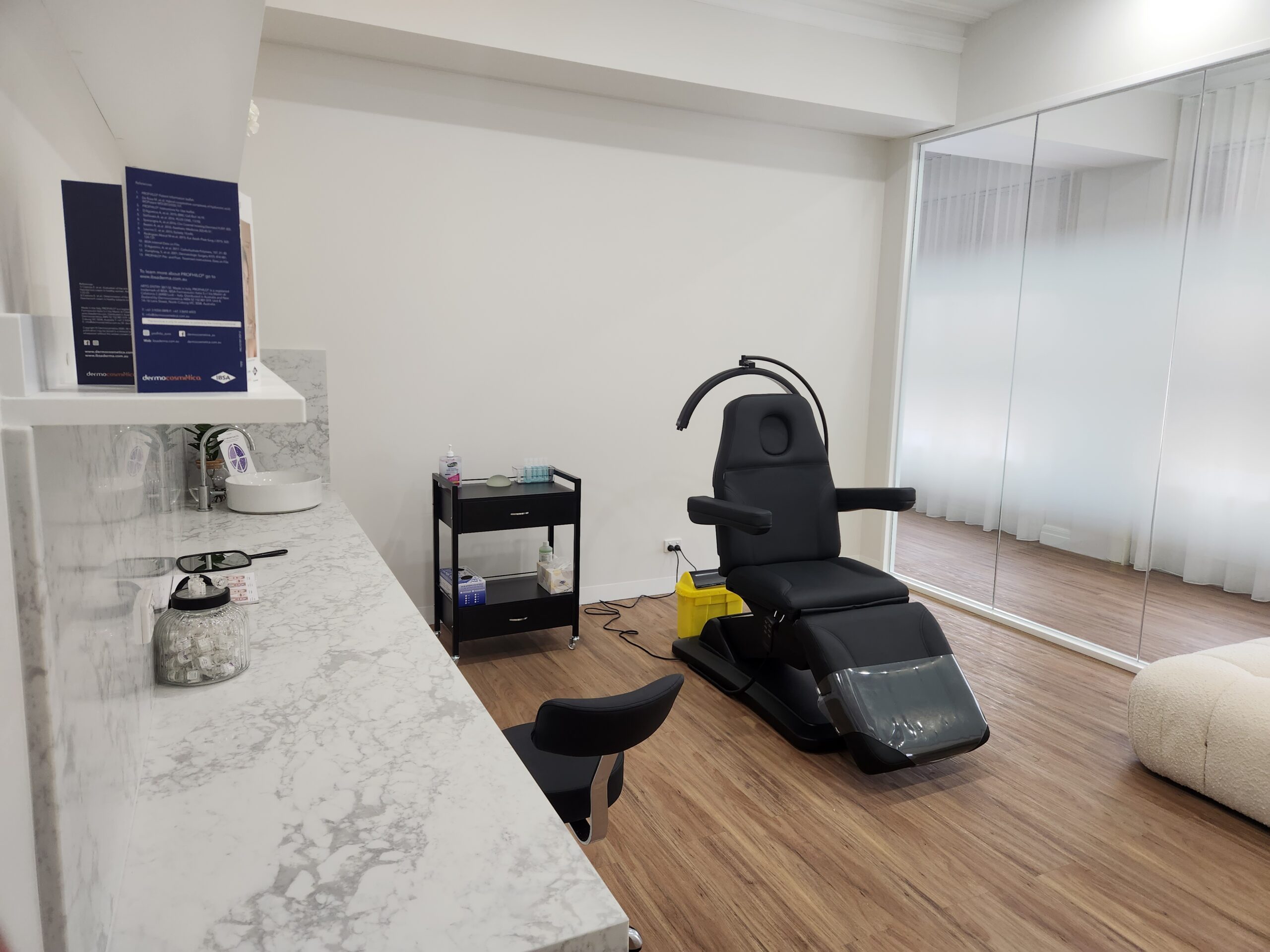 Treatment room for a skin clinic. The fit-out includes stone benchtops and a chair for patients.